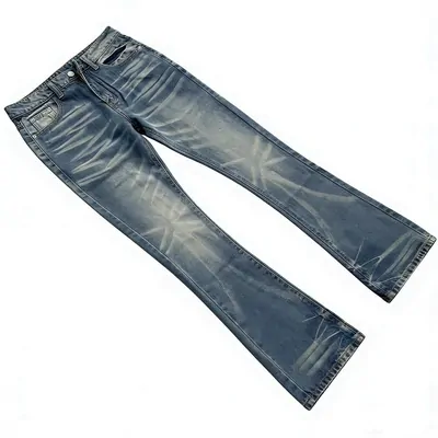 A single pair of mid blue jeans laid flat on white, slightly flared at the ankle with heavy fading down the thighs