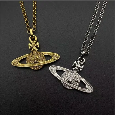 Two orb pendants on chains against black, one gold and one silver set with small crystals