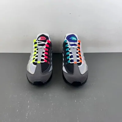 A pair of grey running shoes with a layered sole and multicoloured lace loops, photographed head on against a plain backdrop